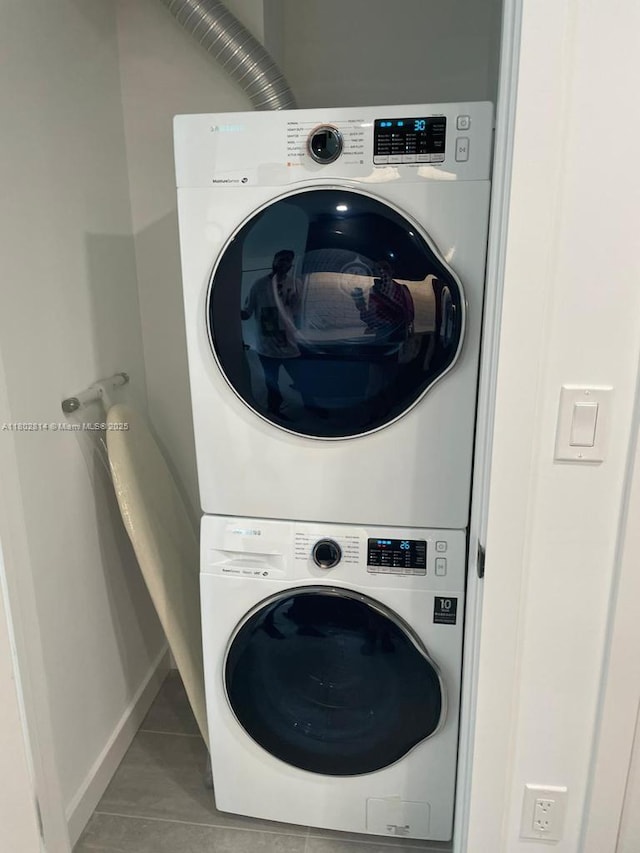 1165 Golden Lakes Blvd Unit 1221, West Palm Beach, FL 33411 - laundry room featuring stacked washer / drying machine, light tile patterned floors, and baseboards