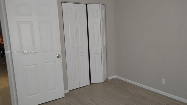 1165 Golden Lakes Blvd Unit 1221, West Palm Beach, FL 33411 - unfurnished bedroom featuring wood finished floors and a closet