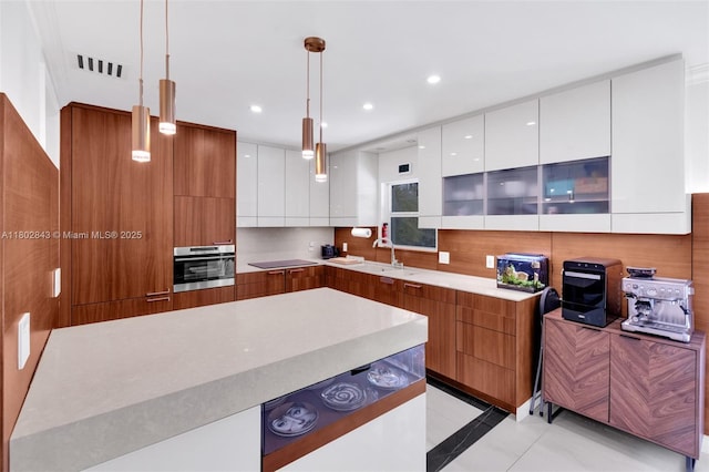 726 NE 17th Way, Fort Lauderdale, FL 33304 - kitchen with modern cabinets, stainless steel oven, a sink, pendant lighting, and white cabinetry