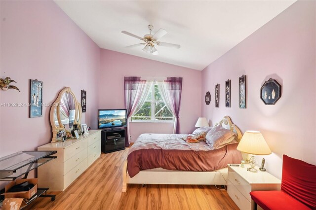 bedroom with lofted ceiling, light wood-style flooring, and a ceiling fan