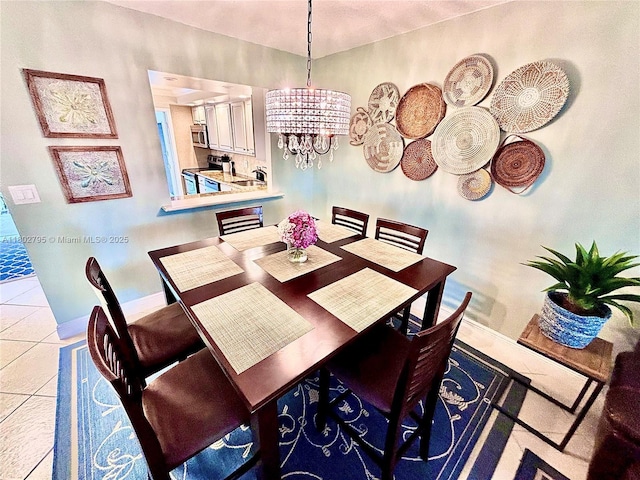 3051 S Palm Aire Dr Unit 203, Pompano Beach, FL 33069 - dining area featuring a chandelier, baseboards, and light tile patterned floors