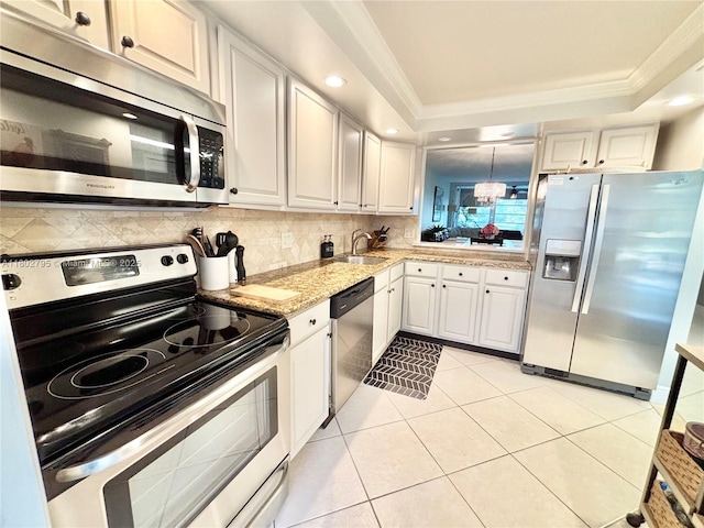 3051 S Palm Aire Dr Unit 203, Pompano Beach, FL 33069 - kitchen with appliances with stainless steel finishes, a sink, ornamental molding, a raised ceiling, and decorative backsplash
