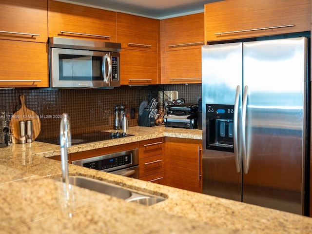 2681 N Flamingo Rd Unit 1206S, Sunrise, FL 33323 - kitchen with appliances with stainless steel finishes, brown cabinets, decorative backsplash, and light stone countertops