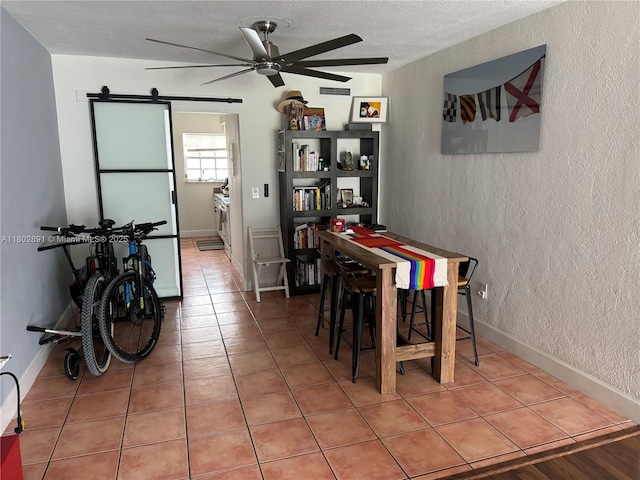 9260 Bay Harbor Ter Unit 24, Bay Harbor Islands, FL 33154 - tiled dining area featuring a textured wall, a ceiling fan, a barn door, and a textured ceiling
