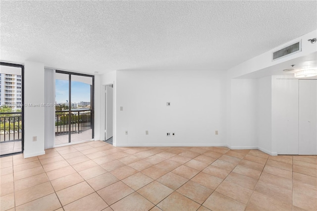 540 Brickell Key Dr Unit 904, Miami, FL 33131 - spare room featuring a textured ceiling, floor to ceiling windows, light tile patterned floors, and baseboards