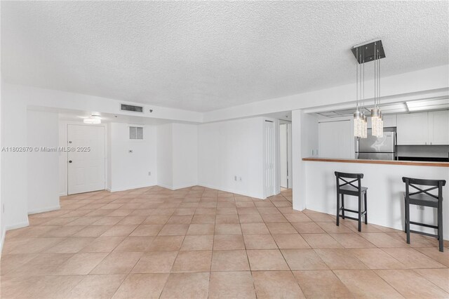 540 Brickell Key Dr Unit 904, Miami, FL 33131 - unfurnished living room with a textured ceiling and light tile patterned floors