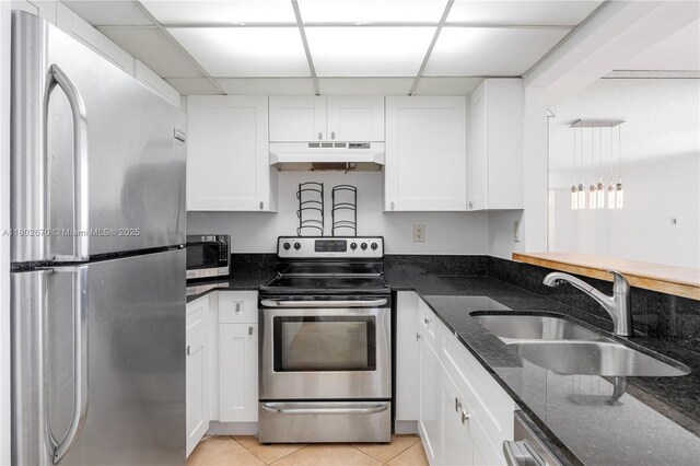 540 Brickell Key Dr Unit 904, Miami, FL 33131 - kitchen featuring appliances with stainless steel finishes, under cabinet range hood, a paneled ceiling, a sink, and white cabinets