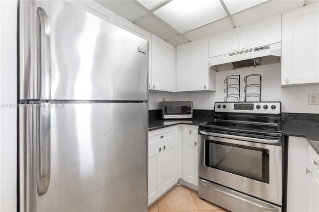 540 Brickell Key Dr Unit 904, Miami, FL 33131 - kitchen with stainless steel appliances, under cabinet range hood, white cabinets, light tile patterned floors, and a paneled ceiling