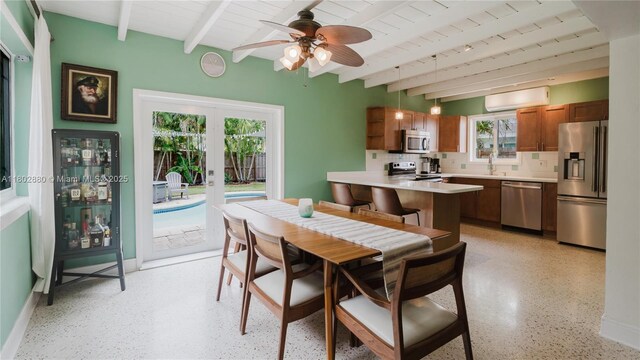 1112 N 31st Ave, Hollywood, FL 33021 - dining space featuring beamed ceiling, dark aggregate flooring, an AC wall unit, a ceiling fan, and french doors