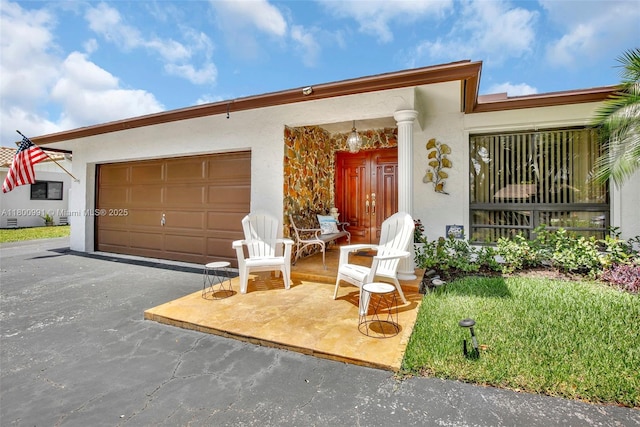 6001 SW 18th St, Plantation, FL 33317 - view of front of property with stucco siding, a garage, and asphalt driveway