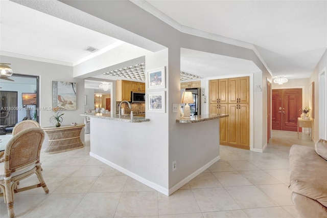 6001 SW 18th St, Plantation, FL 33317 - kitchen with fridge, light tile patterned flooring, stainless steel microwave, ornamental molding, and light stone countertops