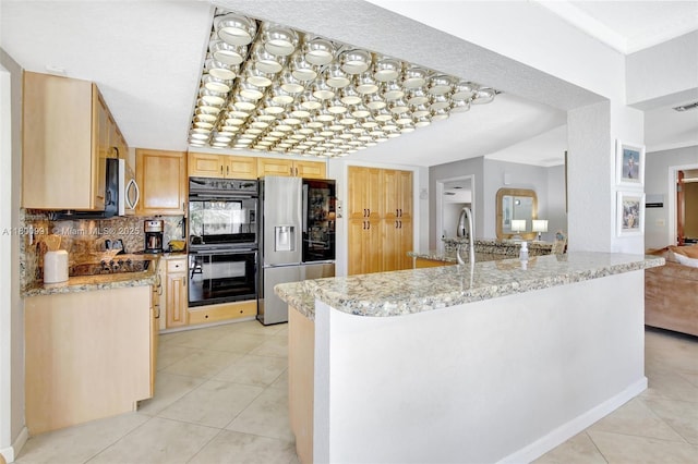 6001 SW 18th St, Plantation, FL 33317 - kitchen with black appliances, light brown cabinetry, light tile patterned floors, and light stone counters