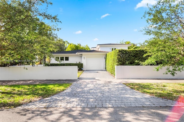 1415 Madrid St, Coral Gables, FL 33134 - view of front of property featuring decorative driveway, a garage, stucco siding, and fence