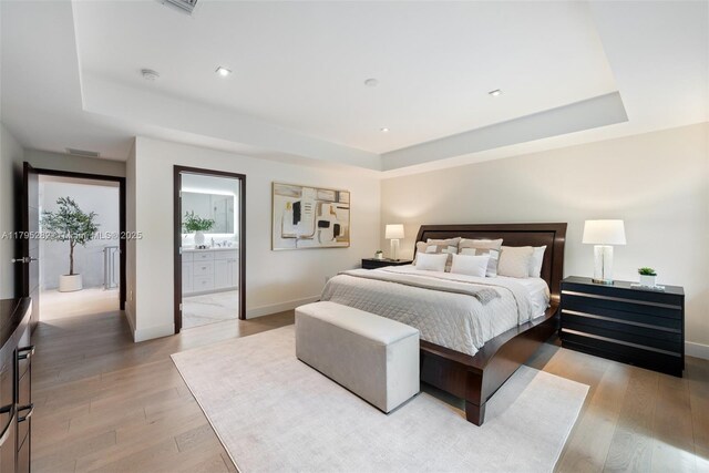 1415 Madrid St, Coral Gables, FL 33134 - bedroom featuring a tray ceiling, light wood-type flooring, baseboards, connected bathroom, and recessed lighting