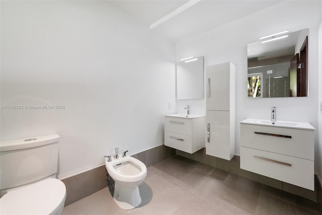 1415 Madrid St, Coral Gables, FL 33134 - full bath featuring a bidet, tile patterned flooring, toilet, and two vanities