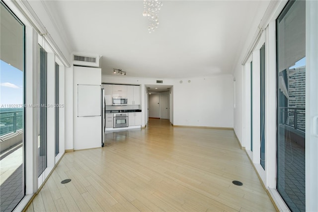 60 SW 13th St Unit 2100, Miami, FL 33130 - unfurnished living room featuring healthy amount of natural light, light wood-style floors, a chandelier, and baseboards