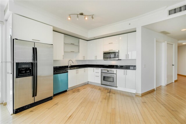 60 SW 13th St Unit 2100, Miami, FL 33130 - kitchen featuring stainless steel appliances, dark countertops, a sink, ornamental molding, and white cabinets