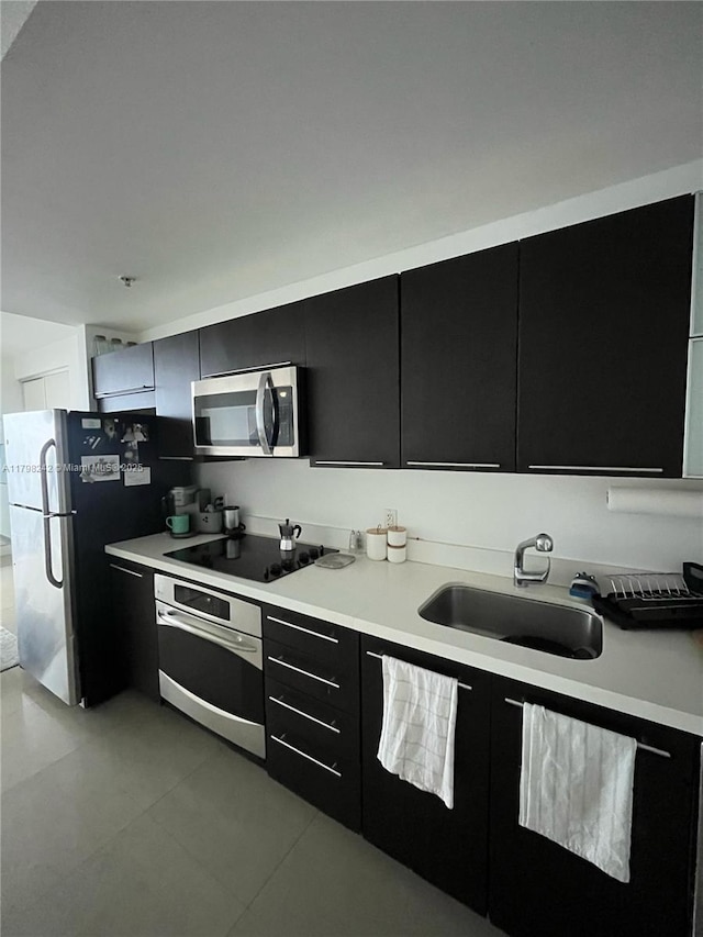 90 SW 3rd St Unit 1909, Miami, FL 33130 - kitchen featuring appliances with stainless steel finishes, dark cabinets, a sink, light countertops, and modern cabinets