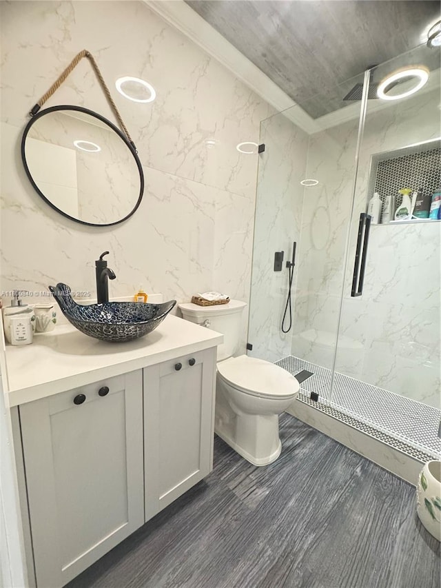 157 La Paloma Rd, Key Largo, FL 33037 - bathroom with a marble finish shower, tile walls, toilet, vanity, and wood finished floors