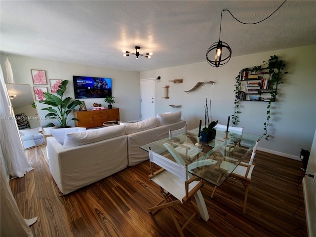 16518 NE 26th Ave Unit 305, North Miami Beach, FL 33160 - living room with a chandelier, wood finished floors, and baseboards