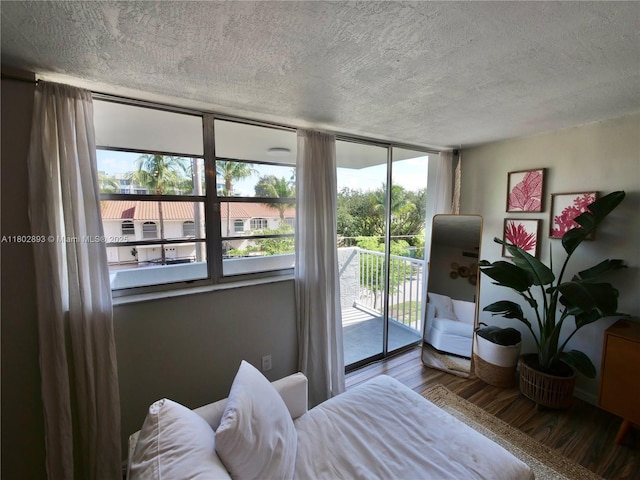 16518 NE 26th Ave Unit 305, North Miami Beach, FL 33160 - bedroom featuring access to outside, a textured ceiling, and wood finished floors