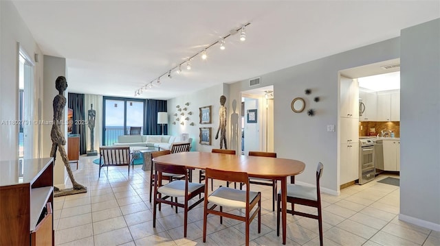 1500 S Ocean Dr Unit 12H, Hollywood, FL 33019 - dining area with light tile patterned floors, rail lighting, and baseboards