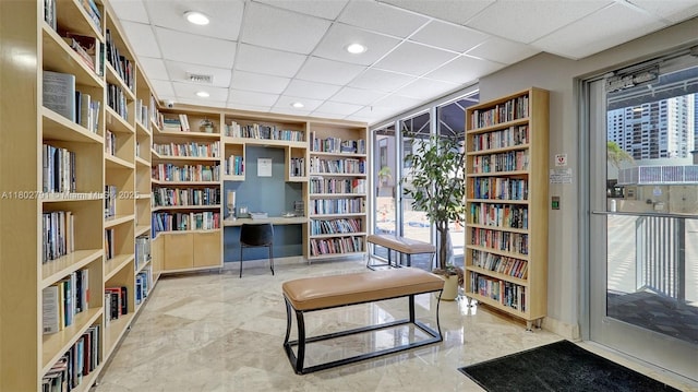 1500 S Ocean Dr Unit 12H, Hollywood, FL 33019 - sitting room with wall of books, a drop ceiling, and marble tiled floors