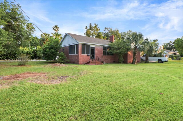 2196 Traymore Rd, Jacksonville, FL 32207 - view of front facade featuring brick siding, a chimney, a front yard, and entry steps