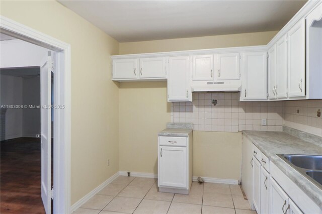 2196 Traymore Rd, Jacksonville, FL 32207 - kitchen featuring under cabinet range hood, tasteful backsplash, white cabinets, and light countertops
