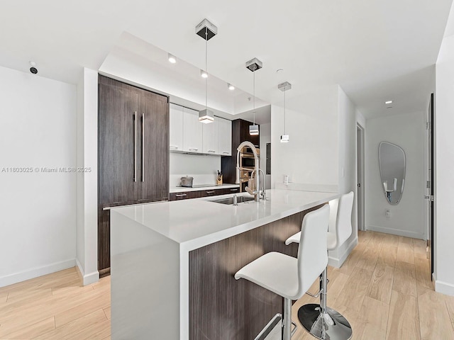 500 Brickell Ave Unit 2203, Miami, FL 33131 - kitchen with light wood-style flooring, a kitchen bar, baseboards, light countertops, and recessed lighting