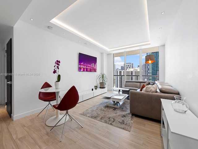 500 Brickell Ave Unit 2203, Miami, FL 33131 - living room featuring a tray ceiling, a wall of windows, and light wood finished floors