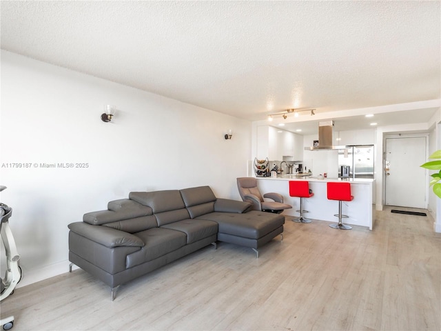 living room with light wood-type flooring and a textured ceiling