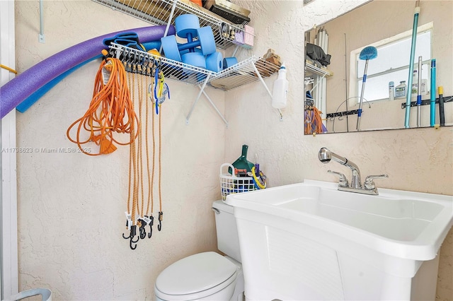 5425 NW 86th Ter, Coral Springs, FL 33067 - bathroom featuring a textured wall, toilet, and a sink