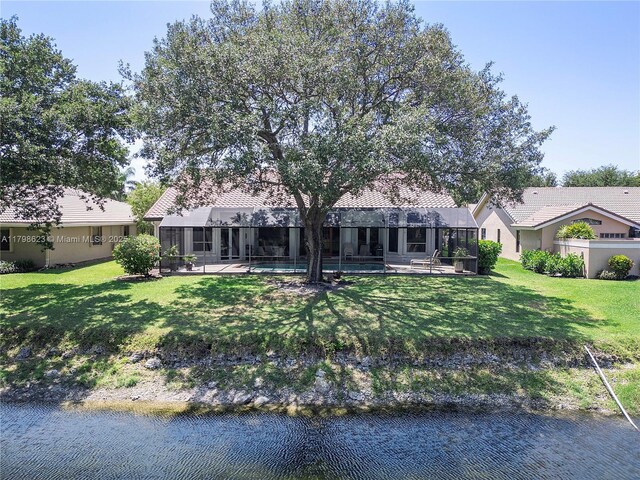5425 NW 86th Ter, Coral Springs, FL 33067 - view of front of house with a water view, an outdoor pool, a front lawn, and a tile roof