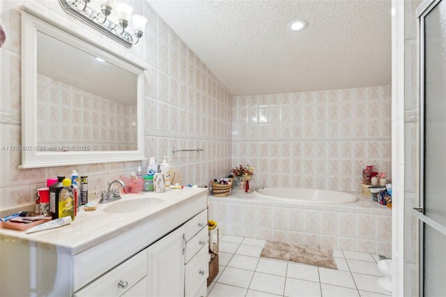 260 Taft Blvd, Clewiston, FL 33440 - bathroom with tile patterned flooring, tile walls, a bath, a textured ceiling, and vanity