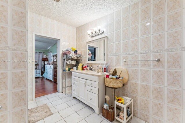 260 Taft Blvd, Clewiston, FL 33440 - bathroom with tile walls, tile patterned flooring, a textured ceiling, and vanity