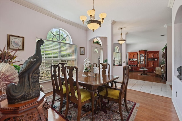 19106 Cormorant Cove Pl, Tampa, FL 33647 - dining area featuring crown molding, arched walkways, light wood finished floors, and baseboards