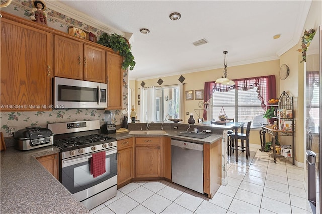 19106 Cormorant Cove Pl, Tampa, FL 33647 - kitchen with stainless steel appliances, a sink, brown cabinets, a peninsula, and dark countertops