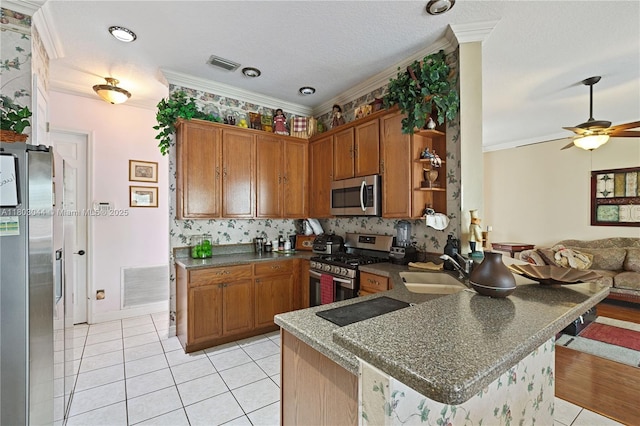 19106 Cormorant Cove Pl, Tampa, FL 33647 - kitchen with appliances with stainless steel finishes, a sink, dark countertops, a peninsula, and brown cabinets