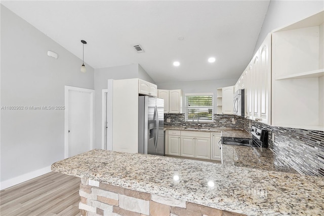 kitchen featuring open shelves, appliances with stainless steel finishes, a peninsula, vaulted ceiling, and backsplash