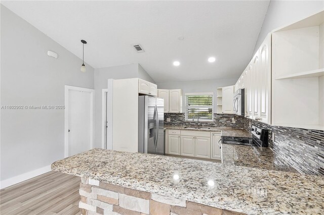 38 E Tara Lakes Dr E, Boynton Beach, FL 33436 - kitchen featuring open shelves, appliances with stainless steel finishes, a peninsula, vaulted ceiling, and backsplash