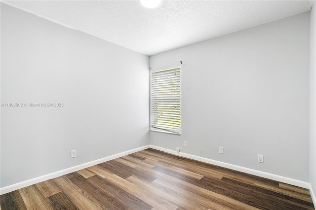spare room with wood finished floors and baseboards