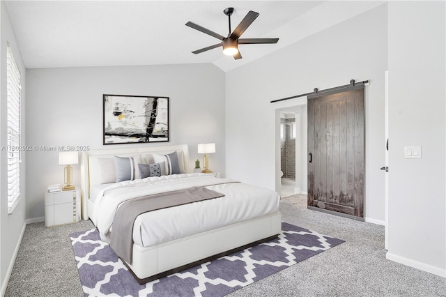 bedroom featuring multiple windows, carpet, vaulted ceiling, a barn door, and baseboards
