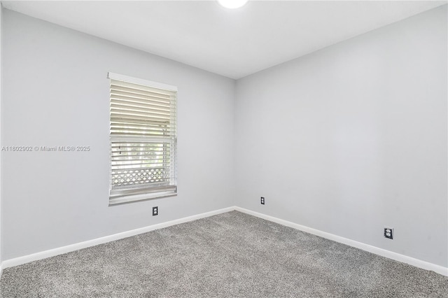 unfurnished room with carpet flooring and baseboards