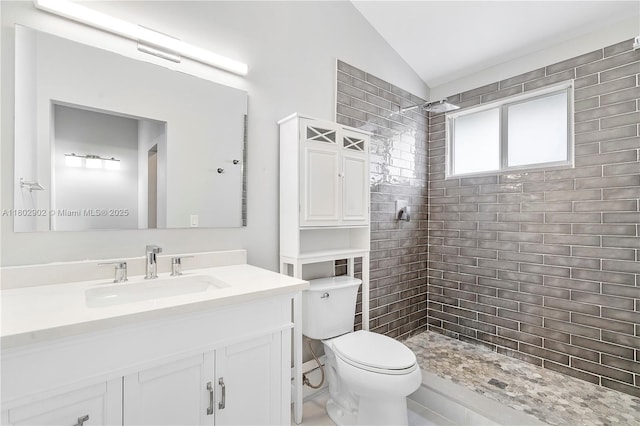 full bathroom with lofted ceiling, tiled shower, toilet, and vanity
