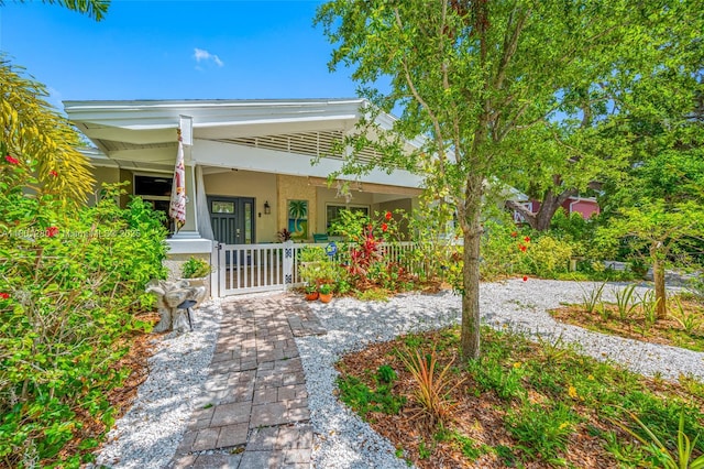 entrance to property featuring a porch and stucco siding