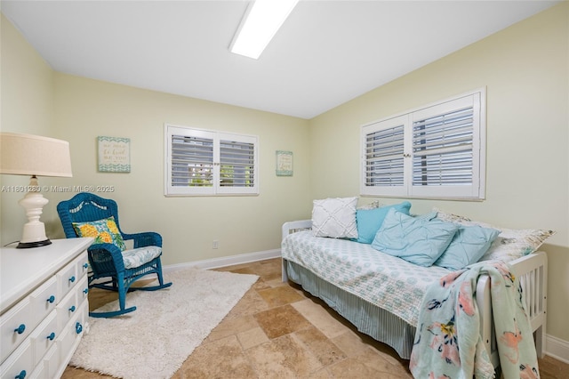 living room featuring light stone finish flooring and baseboards
