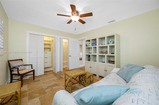 living room featuring stone tile flooring and ceiling fan