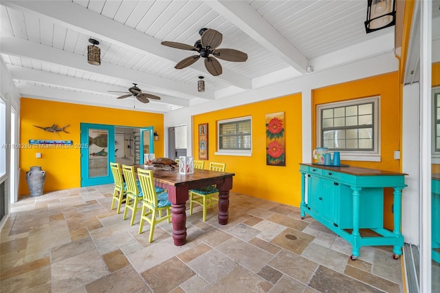 dining room with stone tile floors, a ceiling fan, wood ceiling, and beamed ceiling