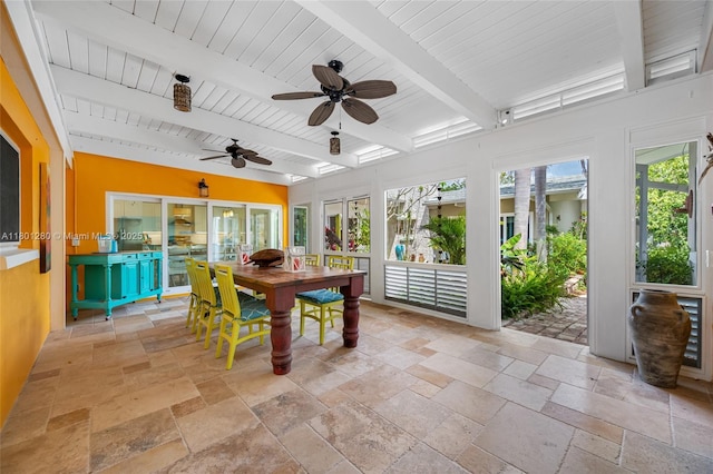 sunroom / solarium with stone tile flooring, beam ceiling, and wood ceiling